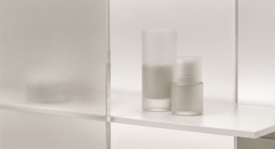 Frosted glass vessels on a translucent matte acrylic shelf